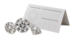 Two or three loose white diamonds next to a folded paper grading certificate, without readable text or a logo