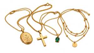 Gold necklaces with pendants: a locket, a cross pendant, a small gemstone pendant and a layered necklace
