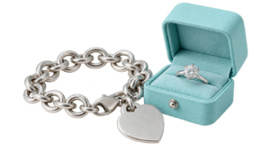 Silver and platinum signature-style pieces: heart tag bracelet, solitaire ring, with a light-blue jewelry box